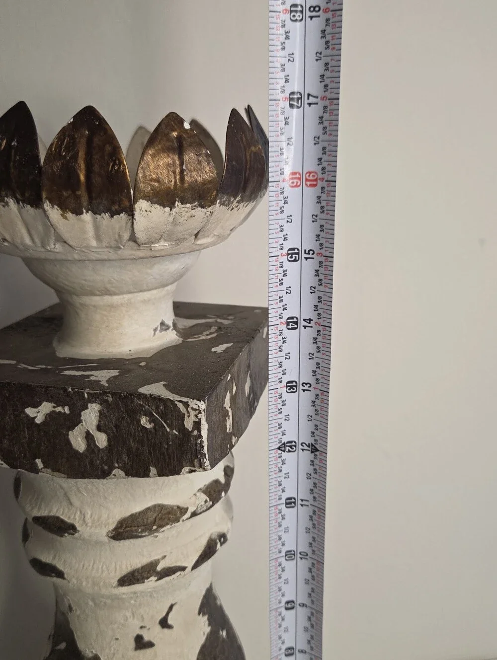 white and gold candlestick features a distressed finish and a lotus-shaped top
